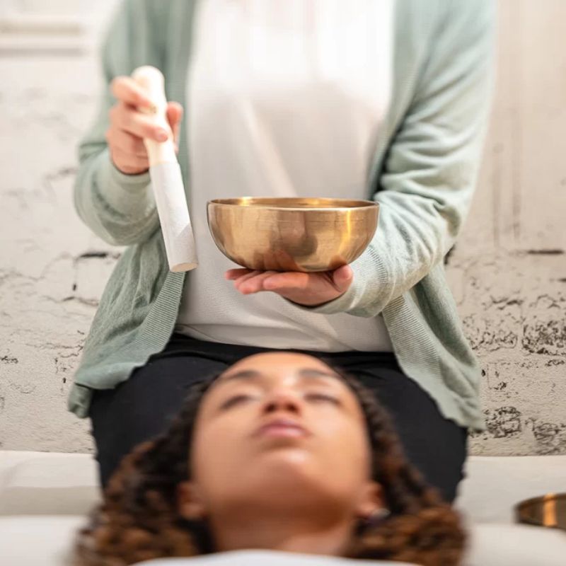 Persona usando un cuenco tibetano en terapia o sanación sonora